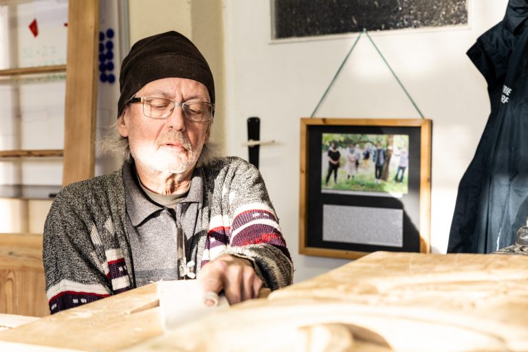Imagefoto in einer Holzwerkstatt des Kommunalen Eigenbetriebs Leipzig / Engelsdorf. Ein älterer Herr arbeitet an einer Werkbank.
