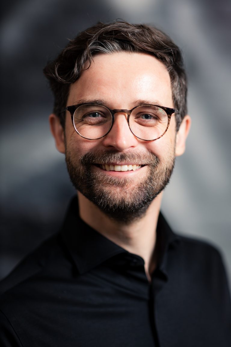Ein junger Mann im Portrait. Dunkle Haare, Brille, er sieht ein wenig aus wie Daniel Radcliff. Portraitfotografie in Leipzig.