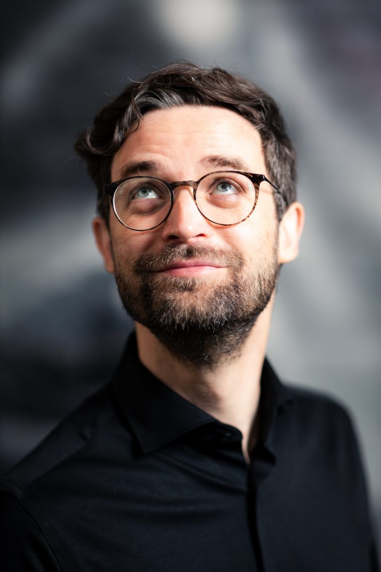 Ein junger Mann im Portrait. Dunkle Haare, Brille, er sieht ein wenig aus wie Daniel Radcliff. Portraitfotografie in Leipzig.