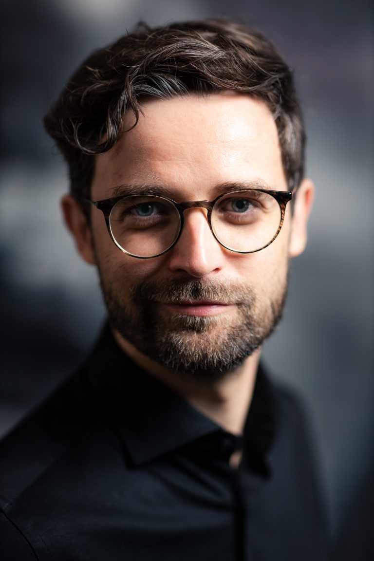 Ein junger Mann im Portrait. Dunkle Haare, Brille, er sieht ein wenig aus wie Daniel Radcliff. Portraitfotografie in Leipzig.