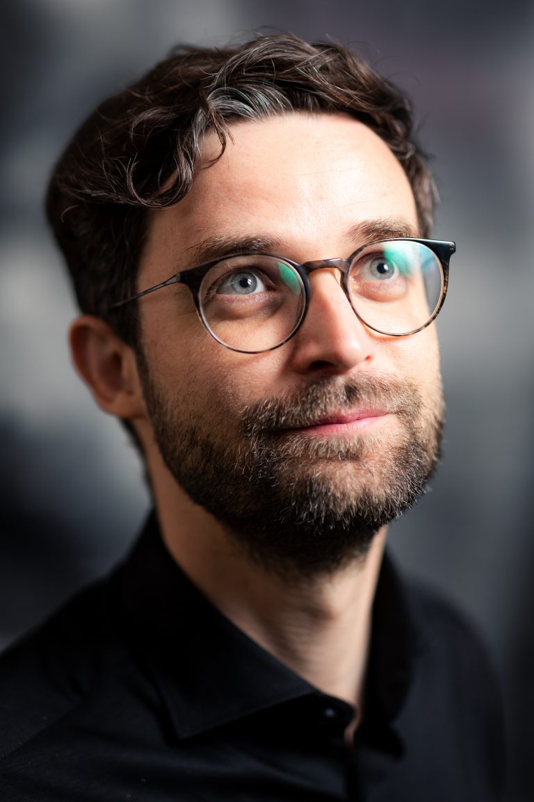 Ein junger Mann im Portrait. Dunkle Haare, Brille, er sieht ein wenig aus wie Daniel Radcliff. Portraitfotografie in Leipzig.