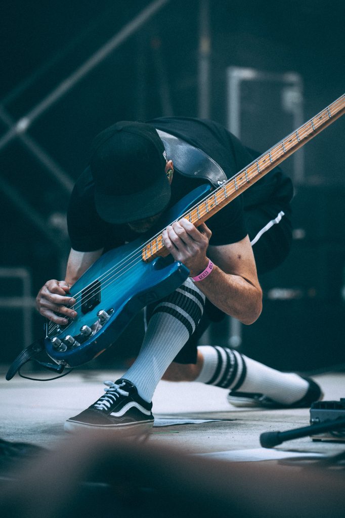 Der Bass geht auf die Knie. Rockstarpose. Konzertfotos aus Leipzig.