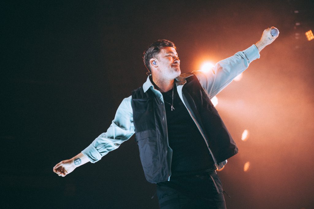 Concert photography Leipzig: Marteria mit weit ausgebreiteten Armen, geschlossenen Augen und Mikrofon in der erhobenen Hand