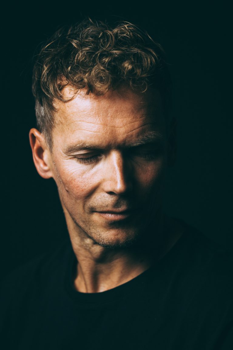 Emotionales Studioportrait eines Mannes vor schwarzem Hintergrund, gesenkter Blick, intime Stimmung, Portraitfotografie Leipzig