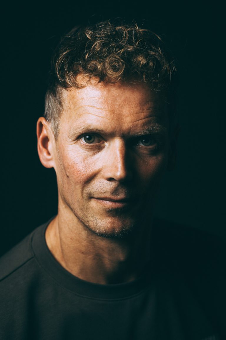 Authentisches Portrait eines Mannes im Studio in Leipzig, Headshot vor schwarzem Hintergrund, ruhiger, souveräner Blick direkt in die Kamera